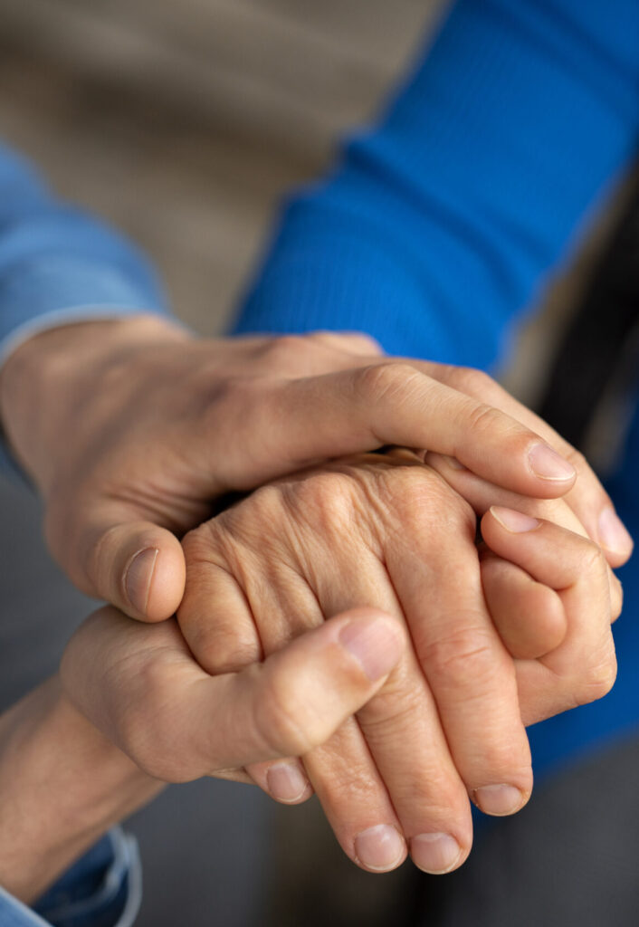 Two hands clasped together in a supportive gesture
